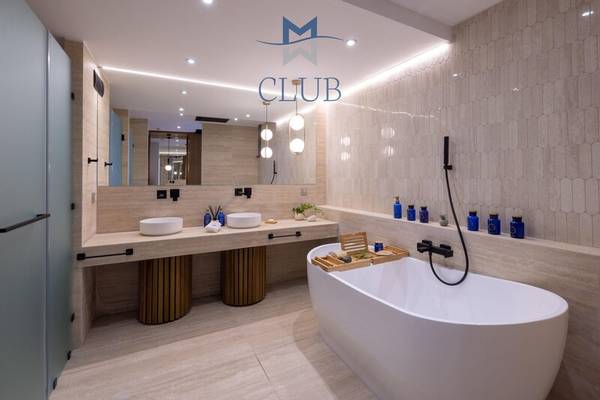 Modernes Badezimmer im Miraggio Thermal Spa Resort Club mit Badewanne, Waschbecken und Club Logo.