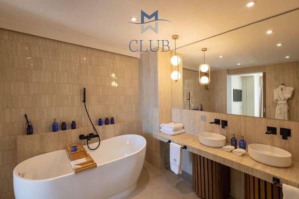 Das Badezimmer im Miraggio Thermal Spa Resort mit Badewanne, zwei Waschbecken und Spiegel.
