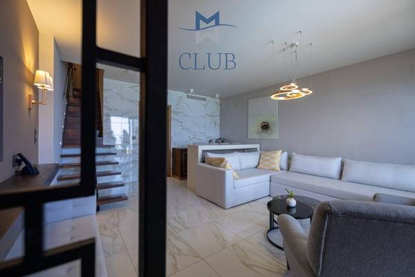 Innenbereich des Miraggio Thermal Spa Resorts mit einer Couch, Tisch und Club Logo.