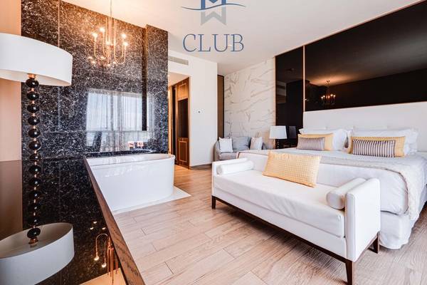 Innenansicht der Club Suite im Miraggio Thermal Spa Resort mit Badewanne und Doppelbett