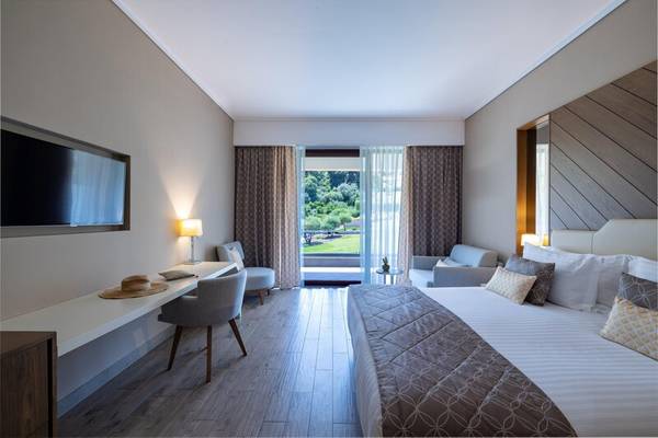 Schlafzimmer im Miraggio Thermal Spa Resort mit großem Bett, Schreibtisch, Lampe und Fenstern