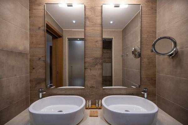 Badezimmer im Miraggio Thermal Spa Resort mit zwei Waschbecken und Spiegeln