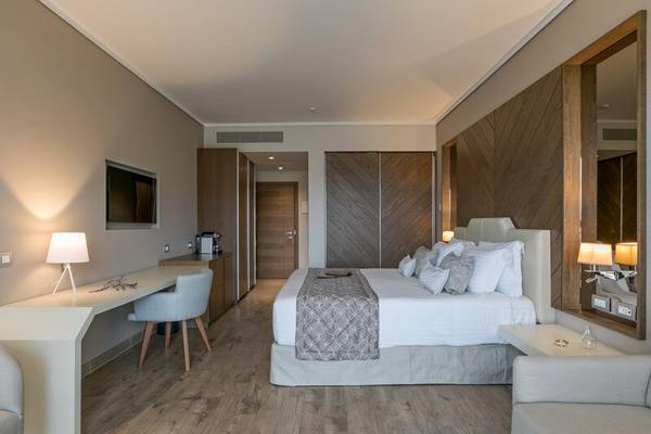 Innenansicht eines Hotelzimmers im Miraggio Thermal Spa Resort mit Bett, Schreibtisch und Sessel.
