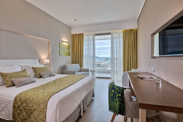 Hotelzimmer im Miraggio Thermal Spa Resort mit großem Bett, Schreibtisch und Aussicht auf den Ozean.