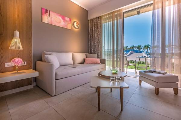 Wohnbereich im Miraggio Thermal Spa Resort mit großem Sofa, Tischen und Fenstern zum Außenbereich.