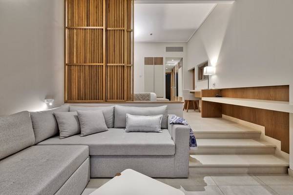 Moderner Wohnbereich im Miraggio Thermal Spa Resort mit grauem Sofa und Holzelementen.