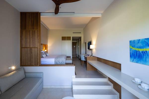 Innenansicht der Suite im Miraggio Thermal Spa Resort mit Bett, Wohnzimmer und Schreibtisch.