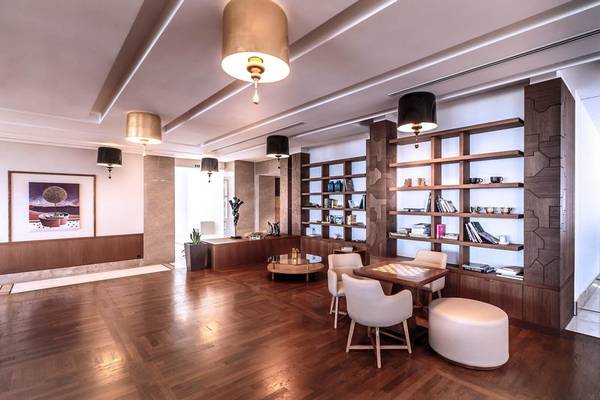 Lobby des Miraggio Thermal Spa Resorts mit Holzboden, weißen Stühlen und Tischen.