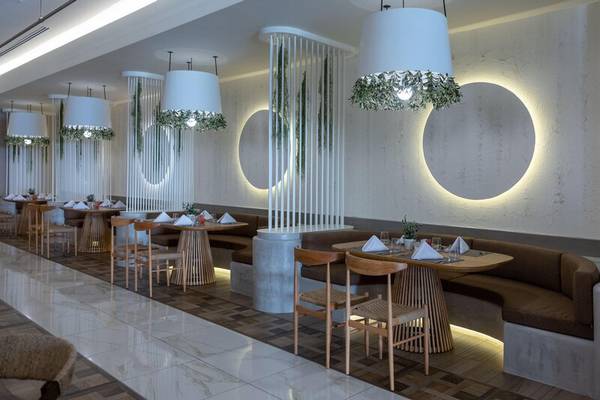 Innenbereich des Restaurants im Miraggio Thermal Spa Resort mit modernen Möbeln und dekorativen Pflanzen.