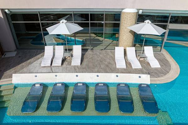 Luftaufnahme des Poolbereichs des Miraggio Thermal Spa Resorts mit Liegen und Sonnenschirmen.