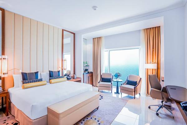 Hotelzimmer mit Meerblick im Rixos Marina Abu Dhabi, mit großem Bett, Schreibtisch und Blick auf das Meer.