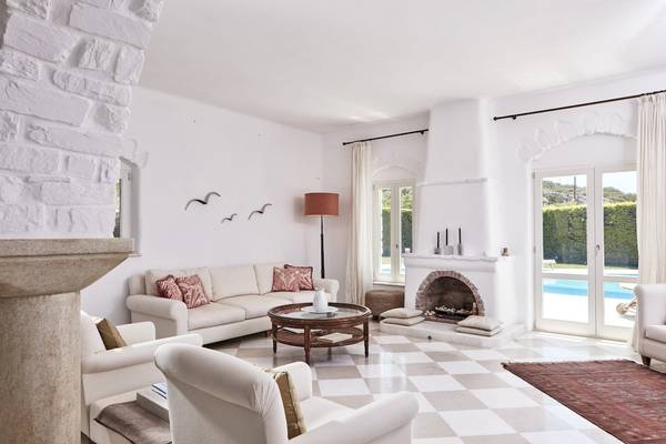 Wohnzimmer des Yria Island Boutique Hotel & Spa mit weißem Sofa, Kamin und Glastüren zum Pool.