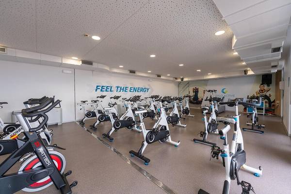 Fitnessstudio im Sentido Galosol Hotel mit Spinrädern und einer Wand mit der Aufschrift 'Feel the Energy'.