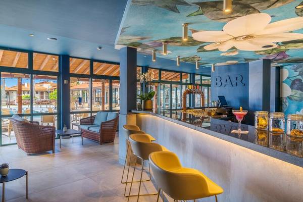 Innenansicht der Bar im Sentido Galosol Hotel mit gelben Stühlen und einer Theke.