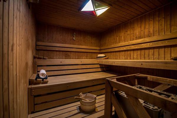 Saunaraum im Sentido Galosol Hotel mit Holzbänken, einem Eimer und einem Handtuch.