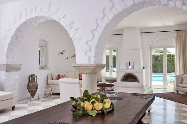 Wohnbereich des Yria Island Boutique Hotel mit einem großen Tisch, einer Schüssel voller Zitronen und einem bogenförmigen Eingang.