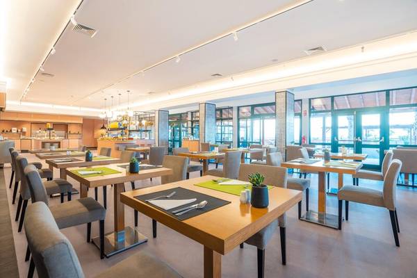 Frühstücksraum im Sentido Galosol Hotel mit Tischen, Stühlen und Pflanzen.