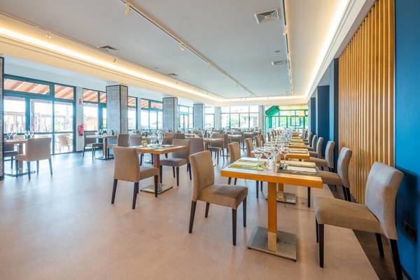 Innenansicht des Restaurants im Hotel Sentido Galosol mit blauen Wänden und freien Tischen.