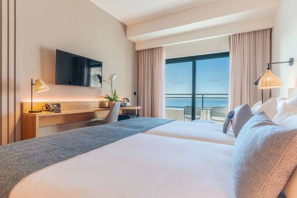 Doppelbettzimmer im Sentido Galosol Hotel mit Meerblick, Fernseher und Schreibtisch.