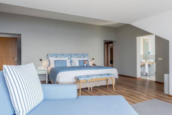 Schlafzimmer im Sentido Galosol Hotel mit großem Bett und blauen Möbeln.