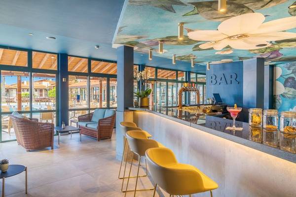 Innenansicht der Bar im Sentido Galosol Hotel mit blauem Dekor und großen Fenstern.