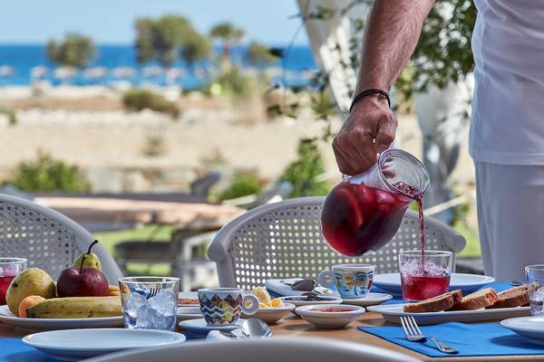 Frühstückstisch im Freien im Yria Island Boutique Hotel & Spa mit Früchten und Getränken.