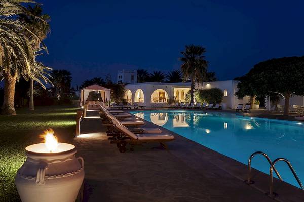Nachtansicht des Yria Island Boutique Hotel & Spa mit Swimmingpool und Liegestühlen.