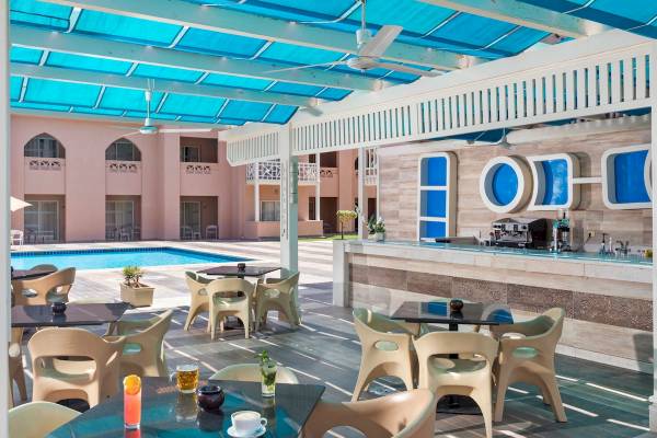 Außenbereich der Poolbar im Pickalbatros Aqua Park Resort mit Tischen, Stühlen und Sonnenschirmen.
