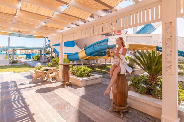 Frau im Pickalbatros Aqua Park Resort - Hurghada mit Ananas und Wasserrutsche im Hintergrund