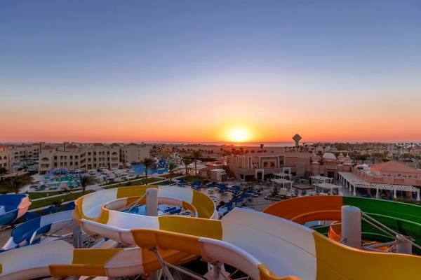 Sonnenuntergang am Pickalbatros Aqua Park Resort in Hurghada mit Blick auf Wasserrutschen und Hotels.