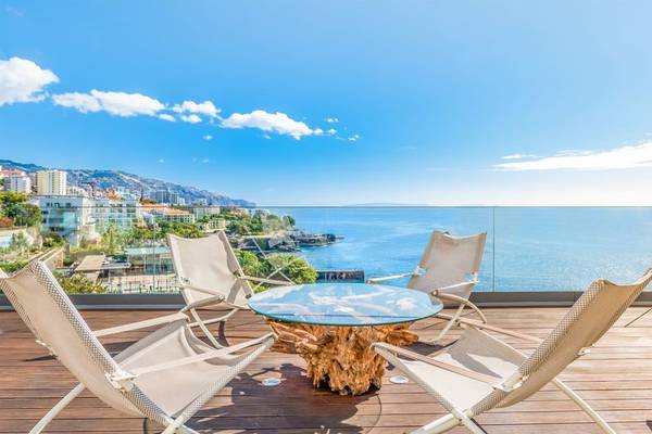 Terrasse des Baia Azul Hotels mit Blick auf das Meer und die Stadt.