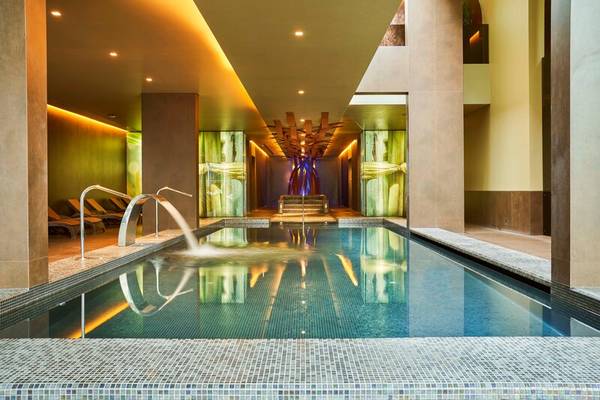 Innenpool des Saccharum Hotels mit Wasserfall und Loungebereich