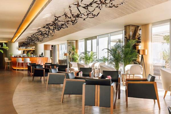 Innenbereich des Saccharum Hotels mit Loungebereich, Stühlen, Tischen und Pflanzen.