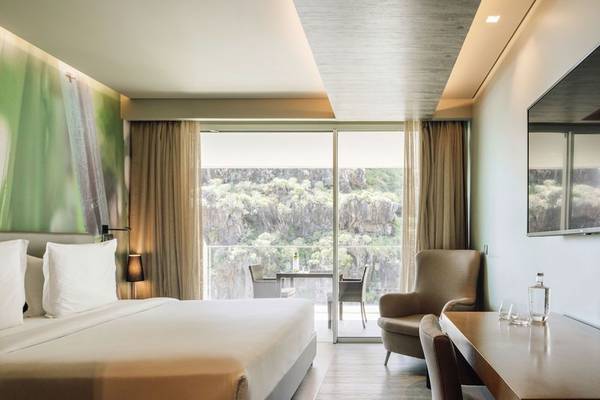 Schlafzimmer des Saccharum Hotels mit Blick auf eine Terrasse und Berge