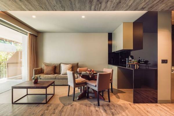 Wohnzimmer des Saccharum Hotels mit einem Tisch, Stühlen und einem Sofa.