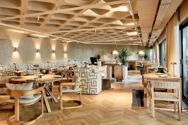 Innenbereich des Suite Hotel Eden Mar mit Holztischen, Stühlen und Pflanzen.