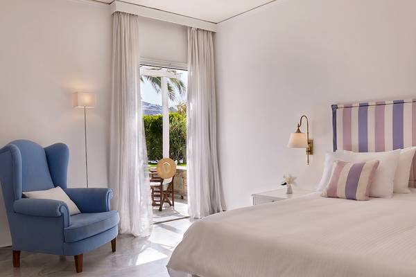 Schlafzimmer mit Bett, Stuhl und offenem Balkon im Yria Island Boutique Hotel & Spa.