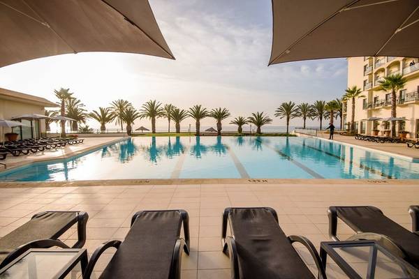 Außenpool des Vila Galé Santa Cruz Hotels mit Liegestühlen und Sonnenschirmen.