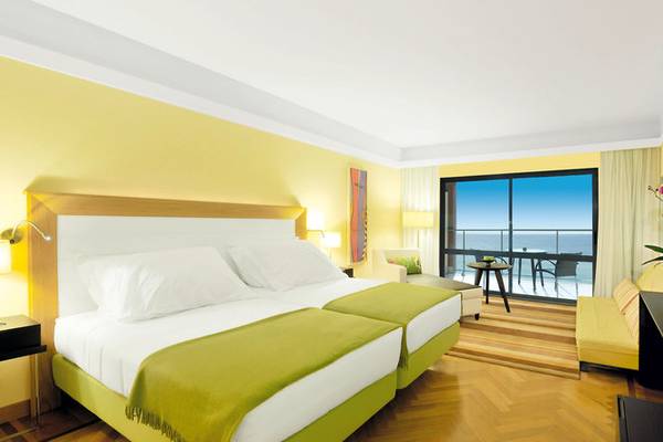 Doppelzimmer im Pestana Promenade Hotel mit Meerblick, zwei Betten, großer Terrassentür und Aussicht auf den Ozean.