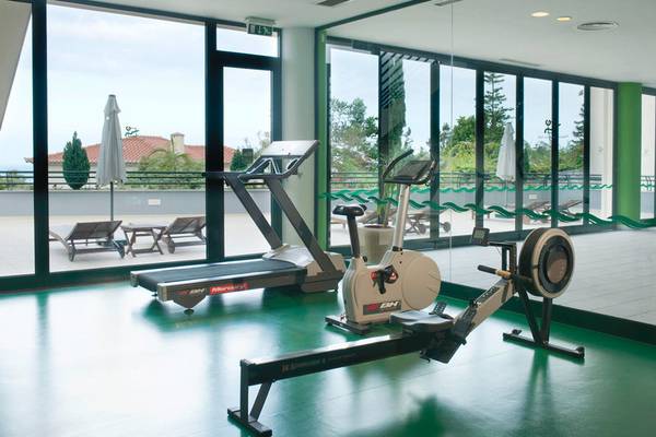 Fitnessstudio im Madeira Panorâmico Hotel mit Geräten und großen Fenstern