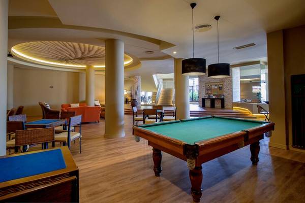 Poolbereich im Calheta Beach Hotel mit Billardtisch und Holzboden.