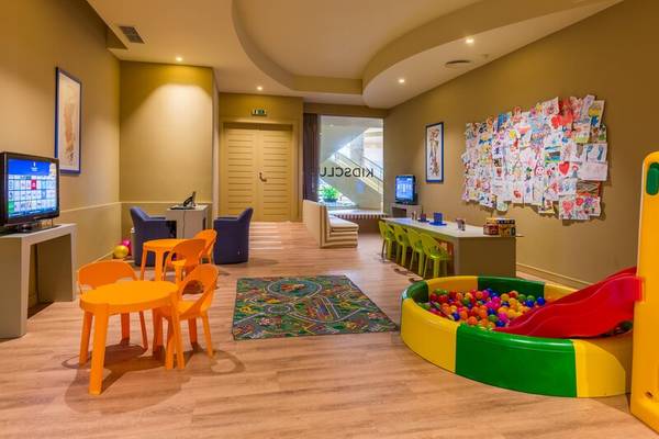 Kinderzimmer im Calheta Beach Hotel mit Spielbereich, Fernseher und Spielsachen.