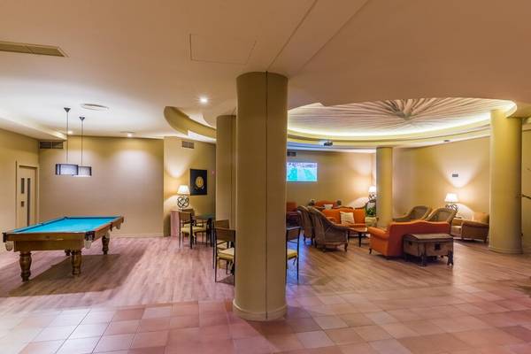 Lobby-Lounge-Bereich des Calheta Beach Hotels mit Billardtisch, Sofas und Tischen.