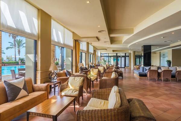 Wohnzimmer des Calheta Beach Hotels mit Blick auf den Pool und Möbeln