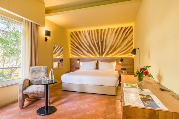 Innenansicht eines Zimmers im Calheta Beach Hotel mit Bett, Tisch und Fenster