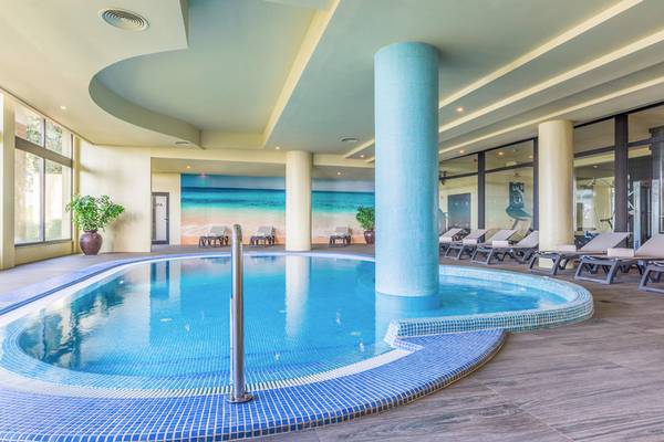 Innenpool des Calheta Beach Hotels mit blauen Fliesen und Sonnenliegen