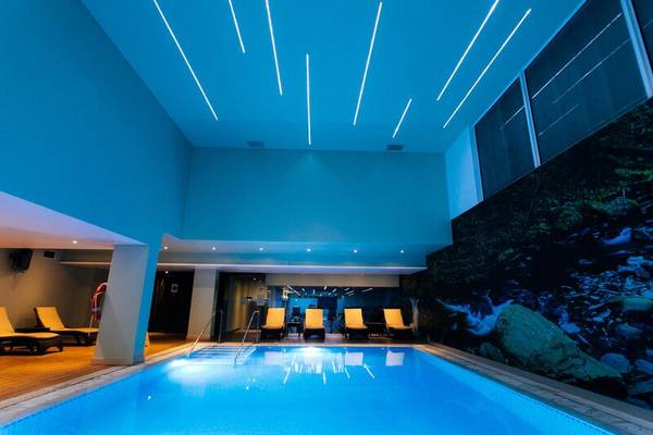 Innenpool-Ansicht des Views Oasis Hotel mit blauer Beleuchtung und Lounge-Bereich.