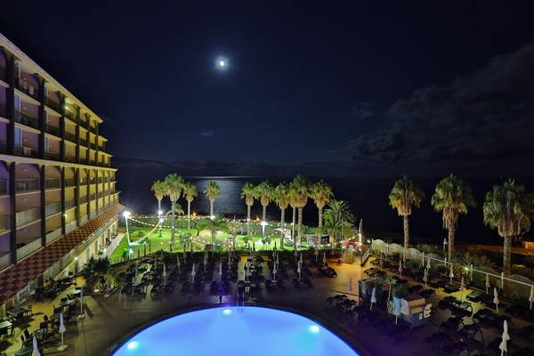 Nachtansicht des Pools des Views Oasis Hotels mit Blick auf den Ozean und den Mond