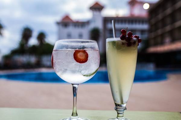 Zwei Getränke mit Eis und Dekorationen stehen auf einem Tisch vor dem Swimmingpool des Views Oasis Hotel.