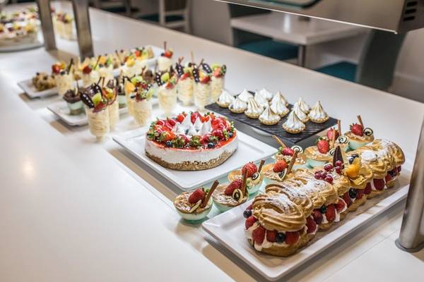 Desserts-Buffet im The Views Oasis Hotel mit verschiedenen Kuchen, Eis und Früchten.